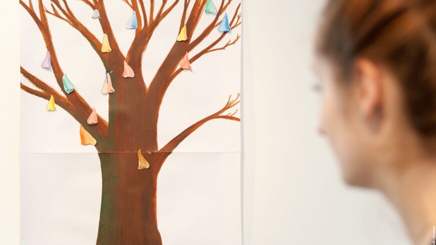 photo d'une jeune participante prenant du recul sur son travail artistique