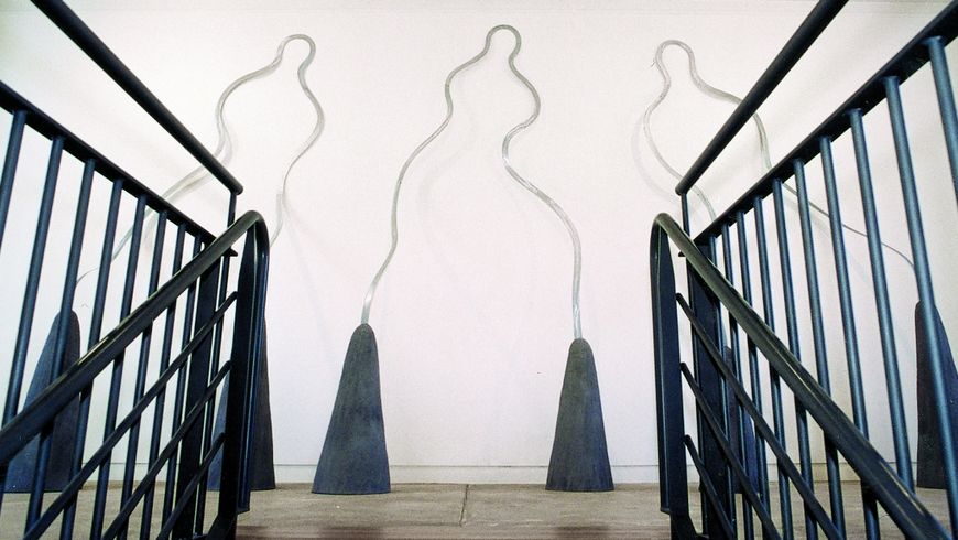 photo du haut des escaliers à la maison des arts avec des sculptures representant des personnages 